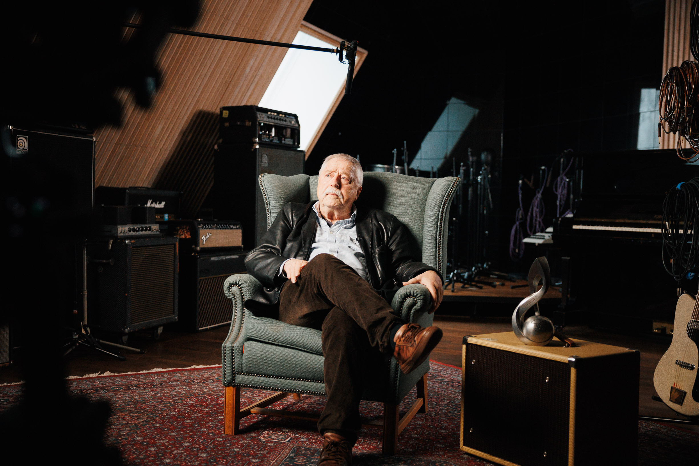 Wolf Biermann nachdenklich auf einem Sessel